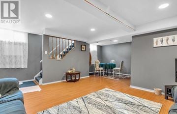Waterloo multi-family for rent - A living room with a staircase and a dining table set up.