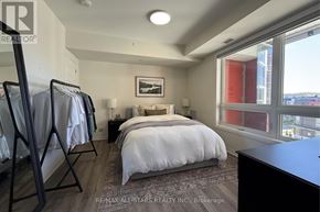 Markham (Cornell) condo for rent - A bedroom with a large bed and a view of the city.