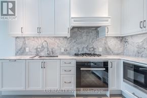 Ottawa condo for rent - A kitchen with white cabinets and a marble backsplash.