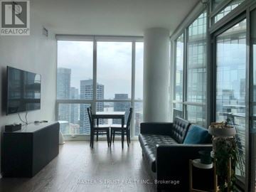 Toronto (Church-Yonge Corridor) condo for rent - A living room with a black couch and a television.