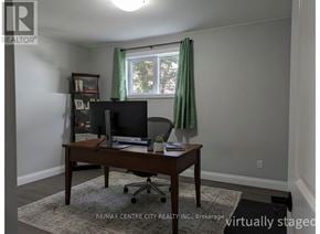 Aylmer apartment for rent - A room with a desk, chair, and a window with green curtains.