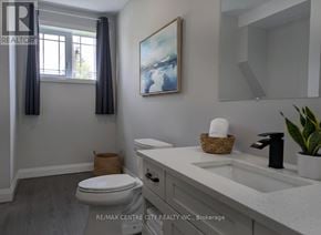 Aylmer apartment for rent - A bathroom with a toilet, sink, and a painting on the wall.