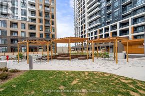 Vaughan (Beverley Glen) condo for rent - A modern outdoor seating area with a pergola and benches is surrounded by high-rise buildings.