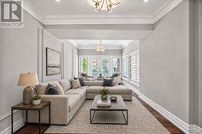 Toronto (Humber Heights) apartment for rent - A well-lit, spacious living room with a large sectional sofa, a coffee table, and a chandelier.