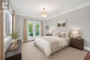 Toronto (Humber Heights) apartment for rent - A bedroom with a large bed, a nightstand with a lamp, and a window with curtains.