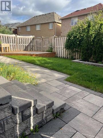 Milton (Co Coates) apartment for rent - A stone walkway leads to a house with a wooden fence.