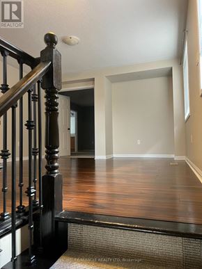 Milton (Co Coates) apartment for rent - A hallway with a wooden floor and a black railing.