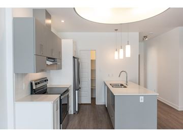 Gatineau (Aylmer) condo for rent - A modern kitchen with a refrigerator, sink, and cabinets.