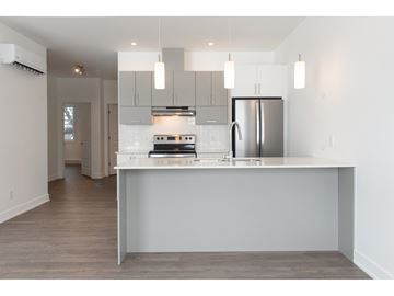 Gatineau (Aylmer) condo for rent - A modern kitchen with a refrigerator, oven, and cabinets.