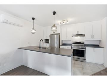Gatineau (Gatineau) apartment for rent - A modern kitchen with a stainless steel island and white cabinets.