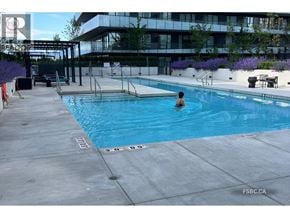 Richmond apartment for rent - A person is swimming in a pool with a building in the background.
