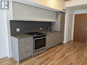 Toronto (South Riverdale) condo for rent - A modern kitchen with wooden floors and a stainless steel island.