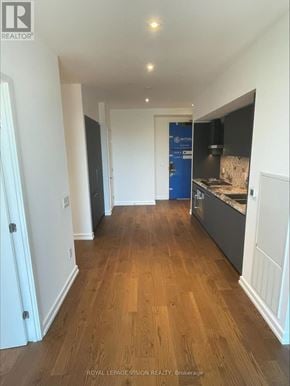 Toronto (Annex) condo for rent - A long hallway with wood floors and white walls.