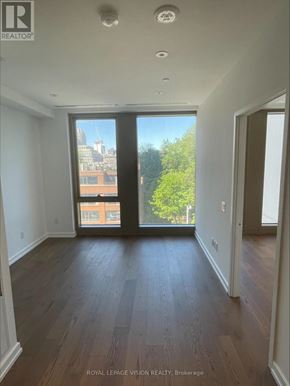 Toronto (Annex) condo for rent - A room with wooden floors and a view of the city through the windows.