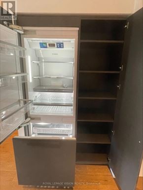 Toronto (Annex) condo for rent - A refrigerator with its door open and shelves visible.