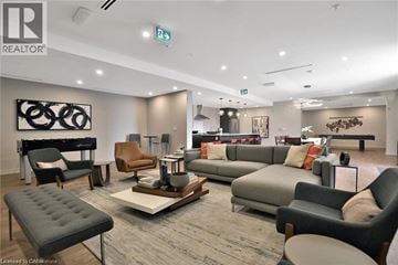 Burlington condo for rent - A living room with a grey sofa and a black and white artwork on the wall.