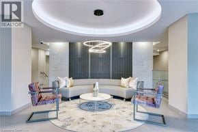 Burlington condo for rent - A modern living room with a circular light fixture and a glass coffee table.