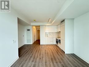 Vaughan (Vaughan Corporate Centre) condo for rent - A spacious kitchen with white cabinets and a wooden floor.
