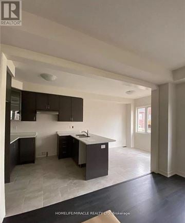 Hamilton (Waterdown) apartment for rent - A kitchen with dark brown cabinets and a white counter top.