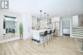St. Catharines (Port Dalhousie) apartment for rent - A modern kitchen with a dining area and a staircase.