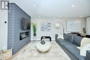 St. Catharines (Port Dalhousie) apartment for rent - A modern living room with a grey couch, a white coffee table, and a grey wall.