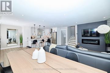 St. Catharines (Port Dalhousie) apartment for rent - A modern living room with a wooden table and grey sofa.