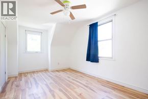 Hamilton apartment for rent - A room with a ceiling fan and a window with blue curtains.