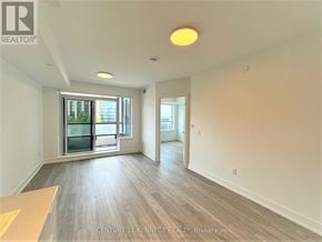Markham (Unionville) condo for rent - A spacious room with a large window and a wooden floor.