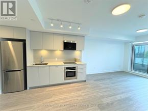 Markham (Unionville) condo for rent - A modern kitchen with a stainless steel refrigerator and a flat screen TV mounted above the counter.