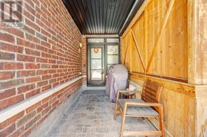 Vaughan (West Woodbridge) townhouse for rent - A wooden bench sits in front of a door on a brick wall.