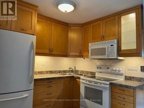 Mississauga (Lakeview) apartment for rent - A kitchen with wooden cabinets and a white refrigerator.
