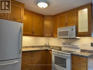 Mississauga (Lakeview) apartment for rent - A kitchen with wooden cabinets and a white refrigerator.