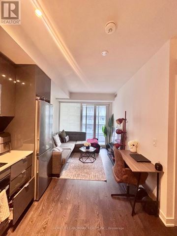 Toronto (Moss Park) condo for rent - A well-lit kitchen with a dining table and chairs.