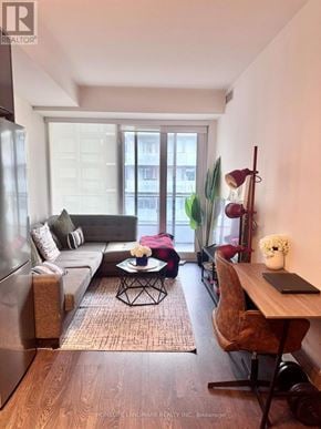 Toronto (Moss Park) condo for rent - A living room with a couch, a chair, a table, and a window.