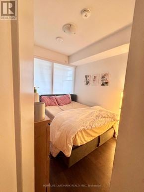 Toronto (Moss Park) condo for rent - A bedroom with a bed, nightstand, and pictures on the wall.