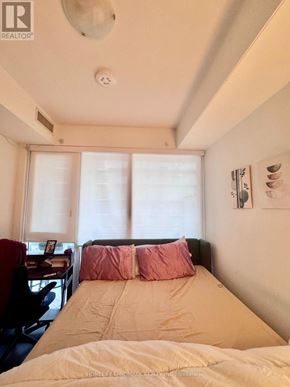 Toronto (Moss Park) condo for rent - A bedroom with a bed, desk, and window.