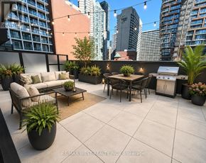 Toronto (Bay Street Corridor) condo for rent - A patio with a table, chairs, and potted plants.