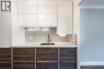 Burlington condo for rent - A modern kitchen with white cabinets and a sink.