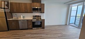 Kitchener condo for rent - A kitchen with wooden cabinets and stainless steel appliances.