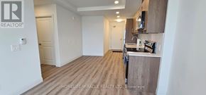 Kitchener condo for rent - A kitchen area with a counter and a fridge.