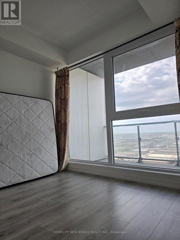 Vaughan (Vaughan Corporate Centre) condo for rent - A bedroom with a large bed and a view of the city.