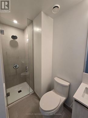 Vaughan (Vaughan Corporate Centre) condo for rent - A white toilet in a small bathroom with a glass shower stall.