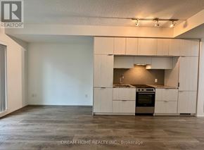 Toronto (Church-Yonge Corridor) condo for rent - A large, empty room with a kitchen area in the background.
