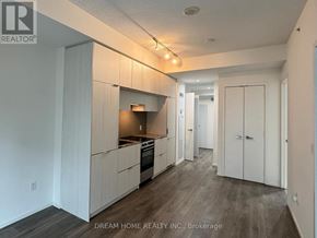 Toronto (Church-Yonge Corridor) condo for rent - A kitchen with white cabinets and a wooden floor.
