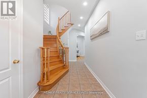 Brampton (Northwest Sandalwood Parkway) apartment for rent - A hallway with a wooden staircase and white walls.