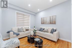 Brampton (Northwest Sandalwood Parkway) apartment for rent - A living room with a white couch and a painting on the wall.