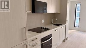 Toronto (Mount Pleasant West) condo for rent - A kitchen with a stove top oven and a microwave above it.