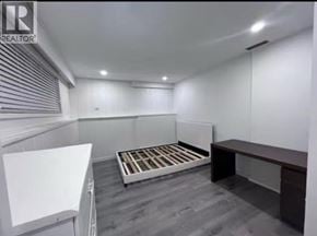 Burnaby apartment for rent - A bedroom with a bed, a desk, and a whiteboard.
