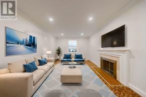 Toronto (Agincourt South-Malvern West) apartment for rent - A living room with a beige couch, a blue cushion, a coffee table, a fireplace, and a painting on the wall.