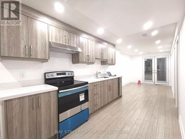 Vaughan (Patterson) apartment for rent - A kitchen with wooden cabinets and a blue stove top oven.